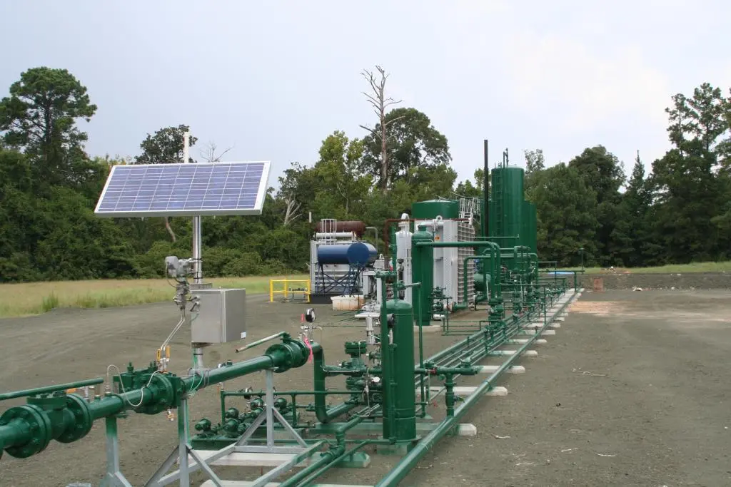 Câmp deschis cu instalație și flare la orizont